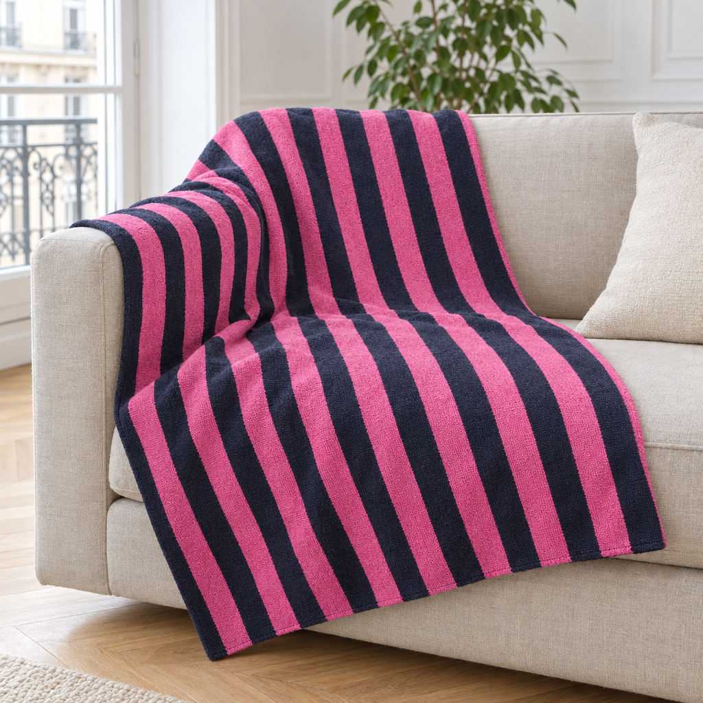 Plaid de canapé à rayures rose et bleu marine posé sur un canapé en lin beige