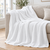 Plaid de canapé en gaze de coton blanc posé sur un canapé en lin beige