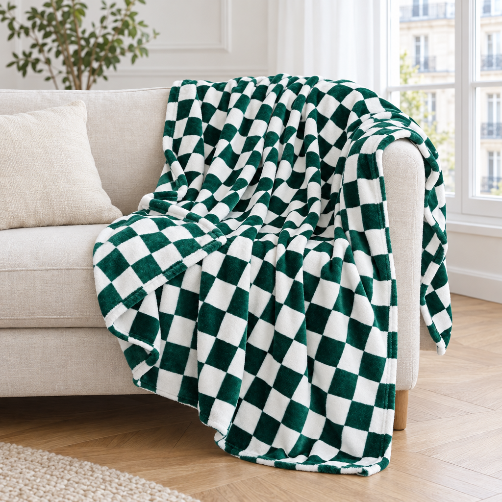 Plaid de canapé en flanelle à damier vert sapin et blanc posé sur un canapé en lin beige