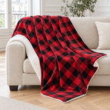 Plaid de canapé à carreaux rouge et noir doublé sherpa posé sur un canapé en lin beige