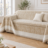 Jeté de canapé en chenille crème et caramel recouvrant un canapé beige