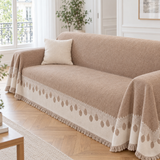 Jeté de canapé bohème taupe à bordure crème à médaillons recouvrant un canapé